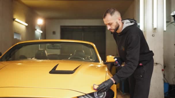 年轻人 汽车抛光工抛光汽车罩 缓冲和抛光带有纳米陶瓷成分或蜡的黄色豪华跑车 车的细节 用于抛光的工具 — 图库视频影像