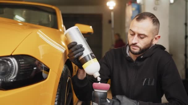 Man Auto Service Worker Wearing Black Clothes Putting Special Polish — Vídeo de Stock