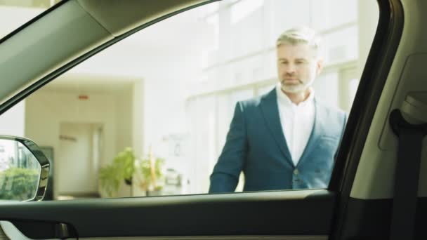 Σοβαρή Μεσήλικας Πελάτης Στέκεται Κοντά Στο Νέο Αυτοκίνητο Στην Έκθεση — Αρχείο Βίντεο