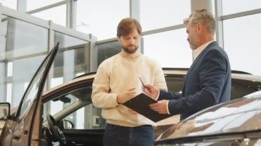 Yakışıklı genç adam yeni bir araba satın alıyor. Profesyonel bir satış sözleşmesi imzalıyor. İmza olarak tüketici yaşam tarzı lüks otomobil sigortası kiralıyor..