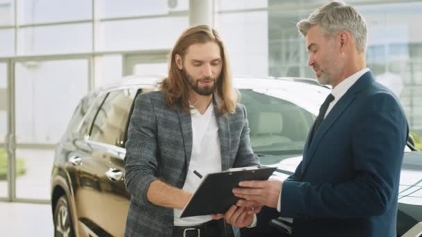 Szczęśliwy Profesjonalny Sprzedawca Klient Podpisują Dokumenty Sprzedaż Lub Wynajem Samochodu — Wideo stockowe