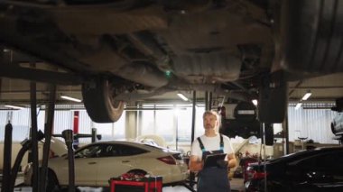 Araba kontrolleri. Otomobil servisi. Becerikli profesyonel orta yaş ustası bakım, yağ değişimi, bilgisayar kontrolleri, yedek otomobil parçaları, fren sisteminin tamiri yapar. Modern araba servisi