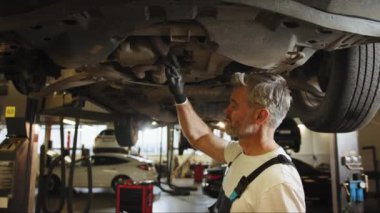 Araba kontrolleri. Otomobil servisi. Becerikli profesyonel orta yaş ustası bakım, yağ değişimi, bilgisayar kontrolleri, yedek otomobil parçaları, fren sisteminin tamiri yapar. Otomatik tamirci.