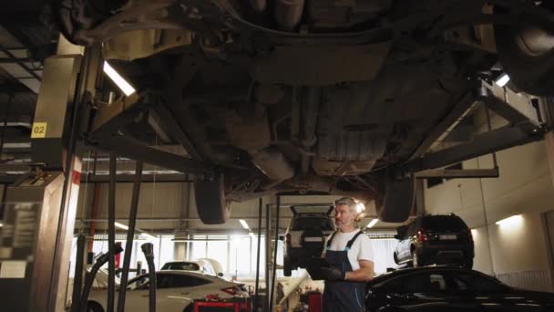 汽车维修方面的汽车技师 专业的中年硕士负责维修 更换机油 更换汽车零部件 修理制动器系统 修理汽车的专业技师 — 图库视频影像