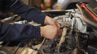İnsan işgali ve iş. Otomobil tamircisi İngiliz anahtarı, araba servisi ve bakımıyla bir araba motoru tamirhanesini tamir ediyor. Onarım servisi