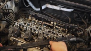 Tanınmayan tamircinin ellerini kapat. Genç oto tamircisi, karşıdaki motoru teşhis için söker ve atölyedeki standda tamir eder. Otomobil tamircisi garajda çalışıyor. Onarım servisi