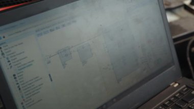 Araba motorunun yanında dizüstü bilgisayarı olan bir tamirci. Modern araba tanılama programı ekranda. Araba servisi konsepti. Tamir ve onarım için motor parçalarının teşhisi ve kontrolü