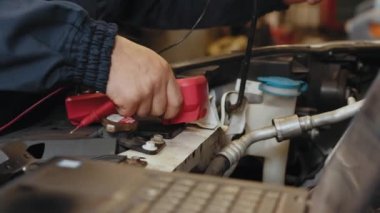 Araba motoru makinesi konsepti, otomobil tamirci tamirci eller dijital multimetre test pil, araba servisi ve bakım ile bir araba motoru otomotiv atölye kontrol hizmetleri.