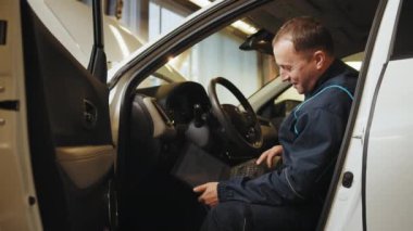 Araba kontrolü için dijital tablet kullanılıyor. Gelişmiş bir bilgisayarda etkileşimli tanı yazılımı. Tamirci tamirhanedeki bilgisayarı kullanıyor. Tamirci arabayı kontrol ediyor, tanı koyuyor..