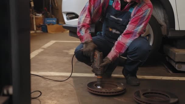 清洗盘式制动器在汽车上 在新的轮胎更换过程中 车库的汽车制动器修理 车库里成熟的中年男人机修工在制动器盘转子重铺服务 — 图库视频影像