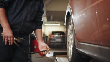 Araba Lastiği Tamirhanesinde Basınç Kontrolü. Lastik şişirme ve hava basıncını kontrol etme detayları mekanik ellerde. Otomatik tamirci araba tamir ediyor