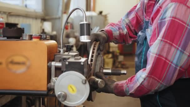 车库的汽车制动器修理 机修工中年男人穿着格子花衬衫 配合专用设备制动器盘转子重铺工作在车库里 — 图库视频影像