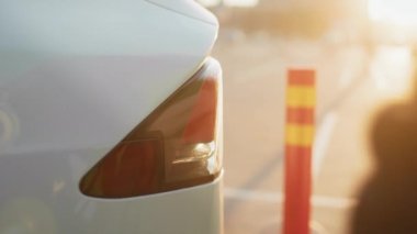 Erkek eliyle elektrik kablosunu açık hava elektrik santralinde beyaz elektrikli arabaya yerleştiriyor. Arka plan bulanık. Bilinçli sahibi olan çevre dostu bir nakliye aracı. Elektrikli araba yükleniyor..