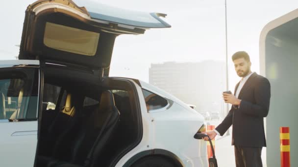 Açık Hava Istasyonunda Elektrikli Araba Şarj Ederken Elbisesi Içindeki Yakışıklı — Stok video