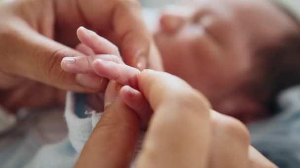 スローモーションで新生児の手を握っている親 手をつないで お父さんと新生児 赤ちゃんが寝ている間に父親の手を握る新しい赤ちゃん 生まれたばかりの赤ん坊と父親の手 郵便局で — ストック動画