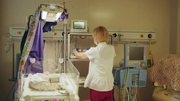 戴防护面罩的女护士在医院工作 新生儿复苏 新生儿复苏 站在孵化器中新生儿旁边的女医生 早产新生儿保健和医疗概念 — 图库视频影像