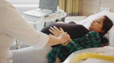 Doğum öncesi bakımı ve hamileliği hesaba kat. Doktor, hastanede ya da klinikte bebek ve anne kontrolü için hamile sağlık hizmetlerini muayene ediyor. Hamile kadın, hamilelik danışmanı olarak jinekoloğa gitmekten mutluluk duyar.