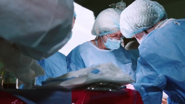 Lekarz Wykonujący Operację Przy Użyciu Sterylnego Sprzętu Zespół Chirurgiczny Wykonujący — Wideo stockowe