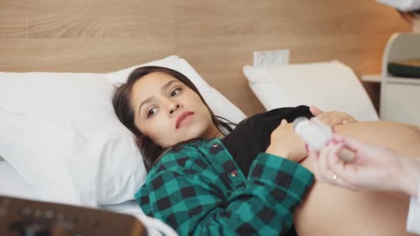 配達室にいる妊婦 妊娠中の女性は ベッドに横たわる晴れた明るい寝室でリラックスしながら 出産前に赤ちゃんと腹を打ちます 女性の健康 出産のコンセプト — ストック動画