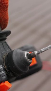 Bir inşaat sahasında, elinde çalışma aleti, matkap ya da elektrikli aletler tutan tanınmayan bir inşaat işçisi. Konsept: İnşaat ve onarım