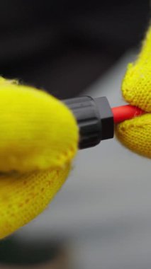 Bir elektrikçi kabloları kontrol ediyor. Elektrik santralinde özel tel sertleştirici. Koruyucu eldivenli bir elektrikçi kabloları yerleştirir. Soya panellerinin bağlantısı.