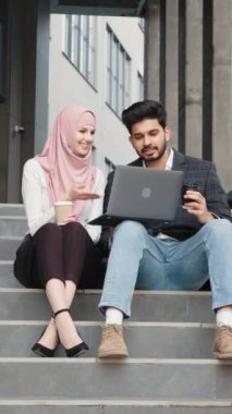 Dikey Ekran: Yakışıklı bir adam ve güzel bir kadın ofis merkezinin yakınında kablosuz bilgisayarla çalışıyorlar. Merdivenlerde oturup uzaktan kumanda yapan iki Arap meslektaşı. Dizüstü bilgisayar kullanan Müslüman erkek ve kadın.