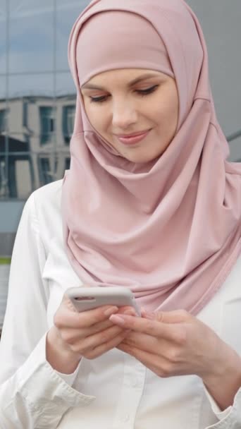 Vertikální Obrazovka Muslimská Žena Pomocí Smartphonu Zatímco Muž Pracuje Notebooku — Stock video