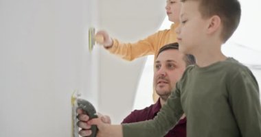 Baba ve iki oğlu DIY ev yenileme projesine giriyorlar. Yeni evlerinin duvarlarını işbirliği içinde boyarlar, gülümsemelerini paylaşırlar ve parlak, modern bir yerde hatıralar yaratırlar..