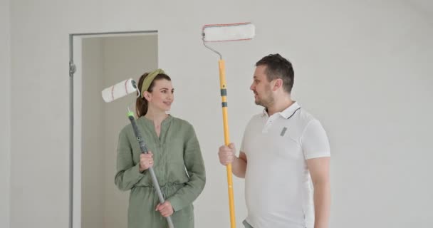 Jeune Couple Heureux Engagé Dans Rénovation Maison Peignant Les Murs — Video