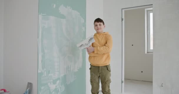 Młody Chłopiec Stoisku Dumnie Nowo Wybudowanym Mieszkaniu Trzymający Tynk Częściowo — Wideo stockowe