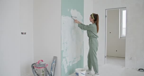 Una Giovane Donna Abbigliamento Casual Rinnova Suo Nuovo Appartamento Dipingendo — Video Stock