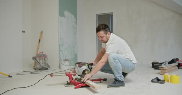 在房屋整修期间 人们在一个新刷好的房间里切木板 翻新工具和油漆桶是可见的 凸显了Diy的改进和自我修复过程 — 图库视频影像