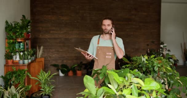 Орієнтований Чоловічий Садівник Фартусі Керує Своїм Процвітаючим Малим Бізнесом Телефону — стокове відео