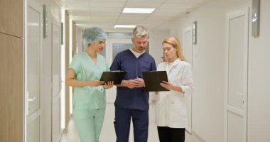 İki doktor ve bir hemşireden oluşan bir tıbbi ekip hastane koridorunda hasta kayıtlarını ve tedavi planlarını tartışıyor. Hastane koridorunda acil sağlık ekibi var. Tıbbi Ekip Hasta Kayıtlarını Tartışıyor