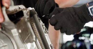 Tamirat ve hassasiyete odaklanarak profesyonel bir oto tamirhanesinde elektrikli araba motoru tamir etmeye çalışan tamircilere yakın çekim. Otomotiv teknolojisi. EV onarım ve servis kavramı.