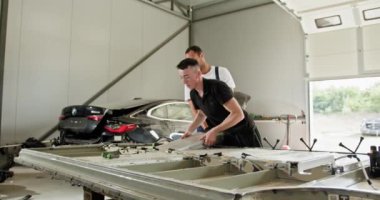 Bir atölyedeki EV araba akü modülünde iki mekanik sorun yaşıyor. Elektrikli Araç Pil Bileşenlerinin Teknik İncelemesi. Otomobil Servisi, Elektrikli Araba Aküsü Taşıma.