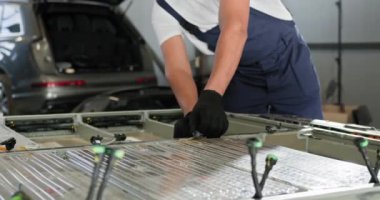 Elektrikli Araç Bataryası Modülü 'nde çalışan erkek teknisyen. Çağdaş Kullanılmış Batarya Otomobil Tamirhanesindeki Araçtan Ayırma. Otomobil servisi, elektrikli araba aküleri. EV Araba Bataryası Atölyede