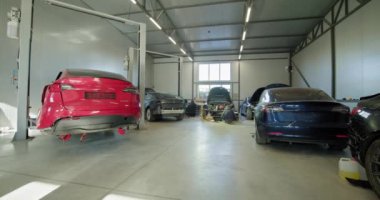 Modern bir otomobil tamirhanesinde çalışan tamirciler, bakım, onarım ve pil işleri yapıyorlar. EV onarım konsepti. Otomobil Servisi, Elektrikli Araba Aküsü Taşıma.