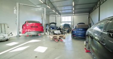 EV onarım konsepti. Otomobil servisi, elektrikli araba aküleri. Modern bir oto tamirhanesinde çalışan tamirciler, bakım, onarım ve pil işleme görevlerini yerine getiriyorlar..