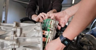 Tamirat ve onarım için bir otomobil istasyonunda kısmen parçalanmış bir elektrikli araba motorunu kontrol etmek ve kontrol etmek. EV onarım konsepti. Otomatik servis, Elektrik motor bakımı
