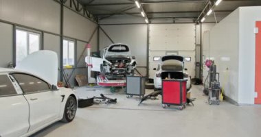 Çok sayıda arabanın tamir edildiği, gelişmiş ekipman ve geniş çalışma alanlarının sergilendiği modern bir araba servisi atölyesinin içinde. Birçok Araba Tamir Edilen Modern Araba Servisi Atölyesi