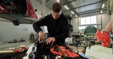 Yetenekli bir teknisyen modern bir otomotiv atölyesinde gelişmiş tamir ve montaj teknikleri sergiliyor. Elektrikli araba. Pil hücre modülü paketi.