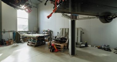 Parçalanmış elektrikli bir motor, EV bakım ekipmanları ve yüksek elektrikli bir araba içeren bir tamirhane. Modern araç hizmeti ve bakım kavramı. EV onarım konsepti. Otomatik Servis