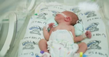 Prematüre bebek sağlıklı gelişim için gerekli bakımı alıyor ve izliyor. Yenidoğan bebekler, yeni doğan yoğun bakım ünitesinde tıbbi ekipmanlarla. Bebek ve hastane ortamı