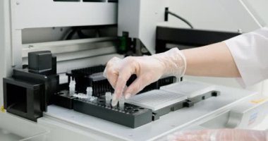 Laboratuvar teknisyeni eldiven takıyor. Bilimsel analiz için mikro levhayı otomatiğe yerleştiriyor. Doğru araştırma ve geliştirme için modern laboratuvar kurulumu. Bilimadamı Mikro Plakayı Yerleştiriyor.