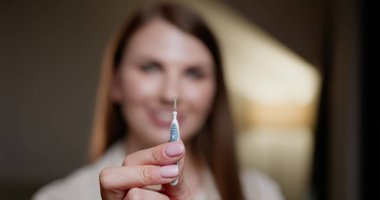 Close-up of young woman holding orthodontic brush used for cleaning braces. Focus on oral hygiene and health care. Concept of maintaining dental braces with proper tools. Dental Braces. clipart