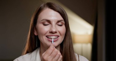 Close-up view of girl cleaning dental braces with orthodontic brush. Focus on metal brackets and oral hygiene practice. Concept of oral hygiene and orthodontic care. Smile with metal brackets. clipart