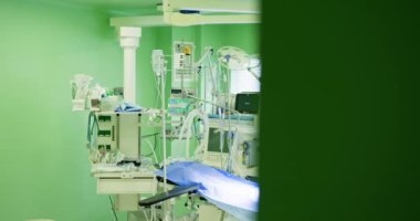 Steril Cerrahi Ortamı Korumak İçin Gelişmiş Tıbbi Malzemelerin Önemi. Yeni tasarlanmış yüksek teknoloji cerrahi odasına ayrıntılı bir bakış, hayati ve gerekli tıbbi cihazları gösteriyor.