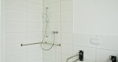 Modern bir banyo, zarif bir duş, çağdaş eşyalar ve parlak beyaz fayanslı duvarlar. Lüks duşlu banyo ve konfor ve işlevsellik için temiz fayanslar.