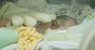 Yenidoğan yoğun bakım ünitesinde destekleyici ekipmanlarla çevrili prematüre bir bebek. Bebek ve tıbbi ekipmanlarla birlikte yeni doğan yoğun bakım ünitesi. Yeni doğan bebek.